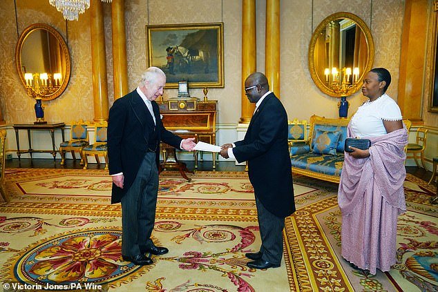 King Charles met the ambassadors of Burundi and Moldova at Buckingham Palace today as the Queen stood in for him at the annual Royal Maundy Service.  Above: The king greets Burundian ambassador Epimeni Bapfinda