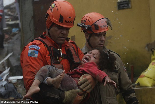 Rescue workers carry Ayla da Silva after the 4-year-old girl was rescued Saturday morning in Petropolis, a city in the southeastern Brazilian state of Rio de Janeiro.  The child spent 16 hours covered in mud, wrapped around the arms of her father, who was murdered