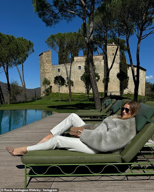 Outside her villa, Rosie relaxed on a khaki green lounger, wearing a huge gray faux fur coat
