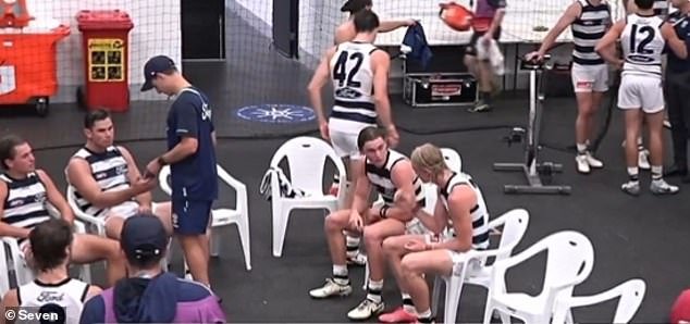 Hawkins insists he was looking at weather patterns on Geelong player development officer Mark Worthington's phone (the two are pictured above) because the fourth quarter was postponed due to a lightning strike