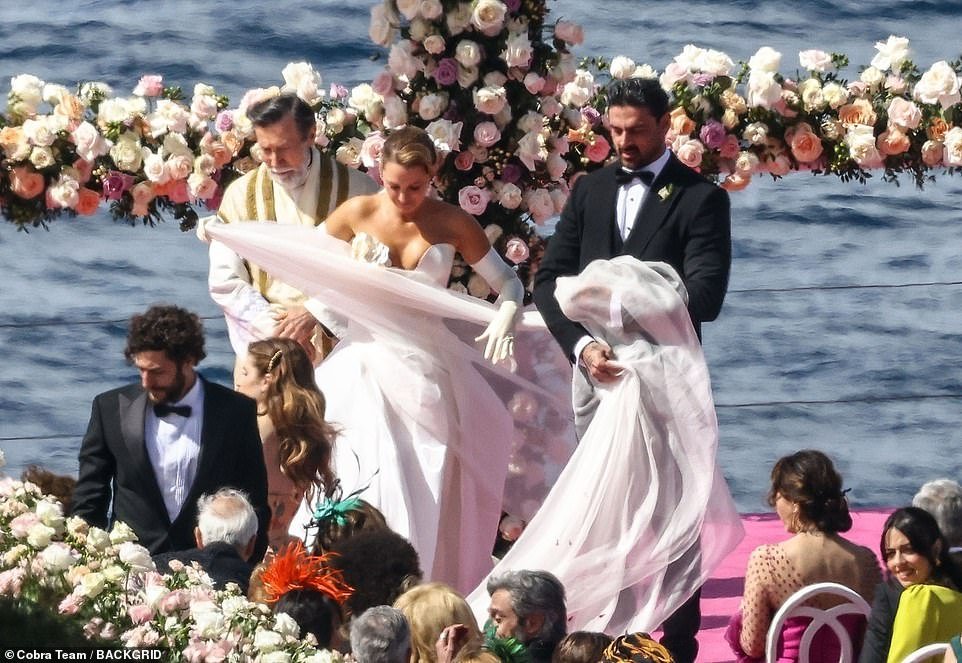 Michele assisted his co-star with her enormous veil