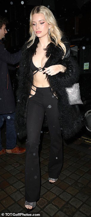 Lottie wrapped herself in a black faux fur coat and added height to her frame with a pair of silver open-toe heels
