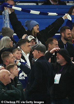 Completely immersed in the exciting atmosphere, Cara hoisted her blue and white scarf above her head