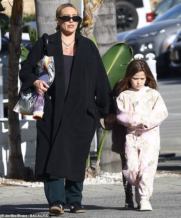 For lunch on Friday, Hilary took her girls to UOVO Italian Cuisine in Studio City, California and she looked stylish in black sunglasses, green pants and a black stretchy top and overcoat