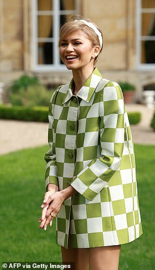 The actress, 27, wore a white and green checked jacket with a high collar as she posed in the venue's gardens