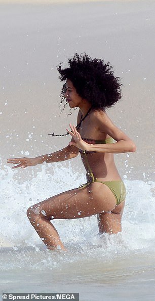 The runway beauty seemed to enjoy splashing in the warm water as the waves rolled towards the shore