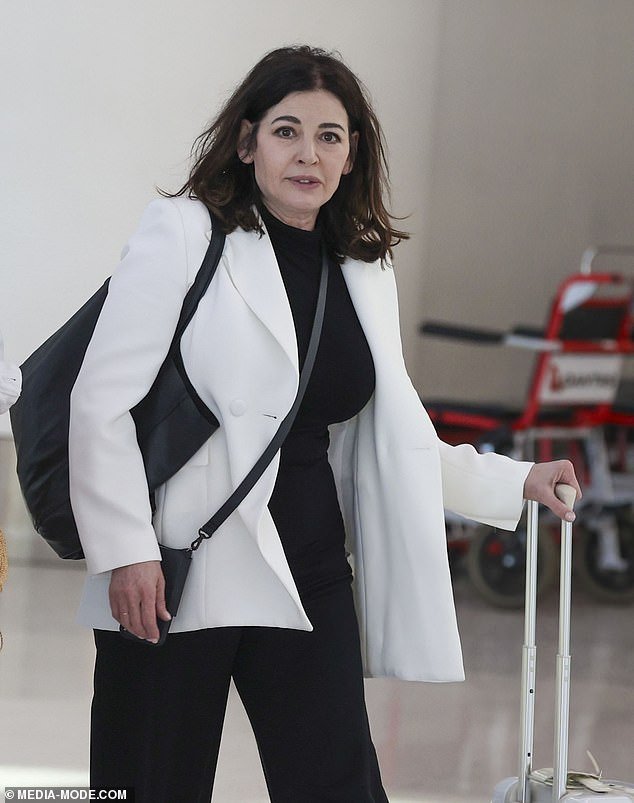The celebrity chef showed she's just like the rest of us as she walked up to a Qantas self-service machine and rolled her bags into the baggage drop area at the terminal.