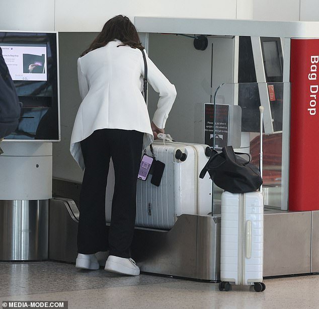 She then weighed her large suitcases before heading to the terminal to board her flight