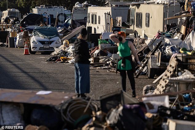 Volunteers help clear out belongings at a homeless encampment near the Nimitz Freeway in Oakland after the city ordered the removal and cleaning of the area where between 30 and 40 people live in cars, RVs, tents and other makeshift structures to make