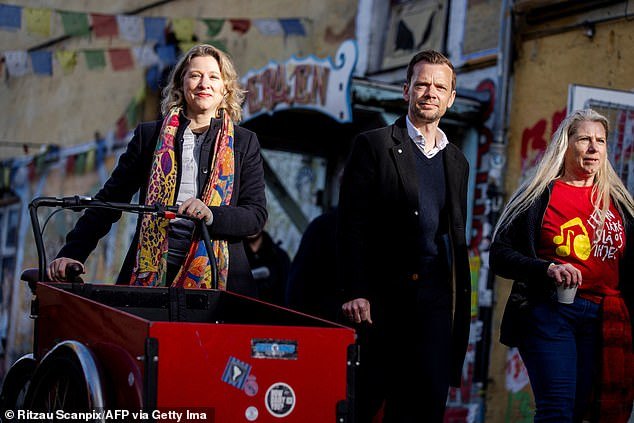 Copenhagen Mayor Sophie Haestorp Andersen (L) and Justice Minister Peter Hummelgaard arrive as Christiania residents jointly dig out the cobblestones of Pusher Street