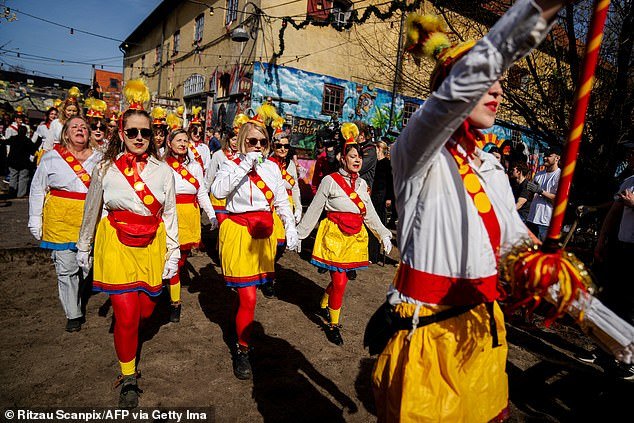 A female band parades down Pusher Street in Copenhagen, Denmark, on April 6, after residents of the Christiania neighborhood dug up cobblestones to officially mark the street's closure