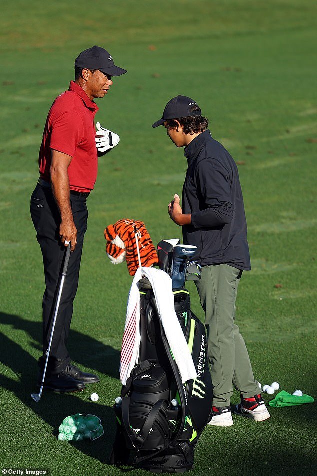 Tiger Woods warms up on the driving range with his son Charlie