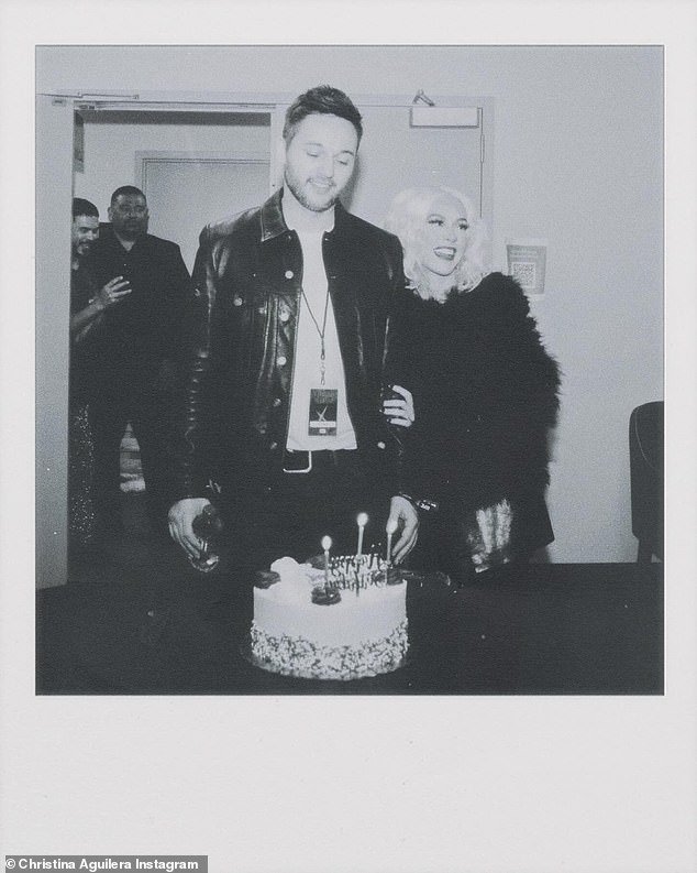 The next slide was a black and white polaroid photo of Xtina and her partner since 2014 admiring his birthday cake