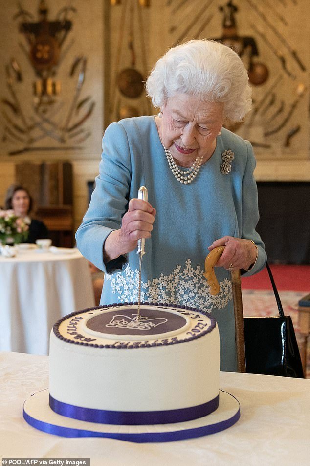 Elizabeth II cuts a cake to celebrate the start of the Platinum Jubilee during a reception in the ballroom of Sandringham House (pictured)
