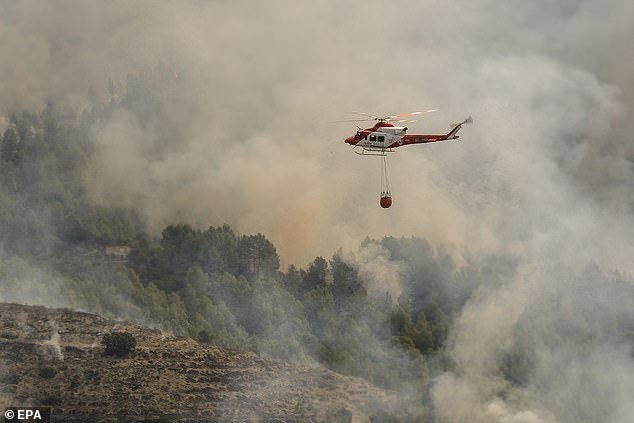 A Spanish firefighting helicopter is seen during a forest fire that broke out in the town of Tarbena, Alicante, eastern Spain, April 15, 2024