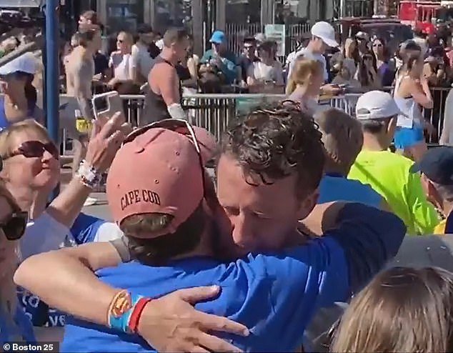 The marathon was a form of therapy for the devastated father (pictured hugging a friend at the finish line on Tuesday).  His partner, depressed midwife Lindsay Clancy, is said to have murdered their three children in January 2023