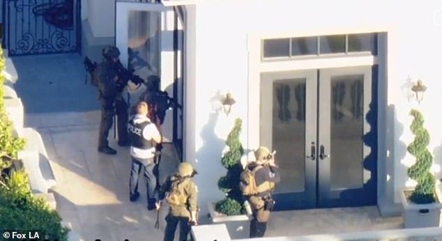 Police were seen outside the massive home, cautiously approaching the front door with weapons in hand.  The motive for the invasion is unclear, but police said it was not a random attack on the house