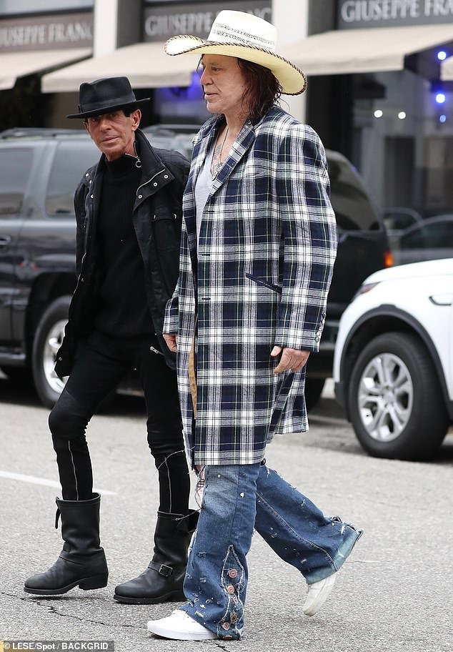 The Academy Award-nominated actor turned heads as he wore a plaid trench coat over a low-cut T-shirt while spending time with his friends