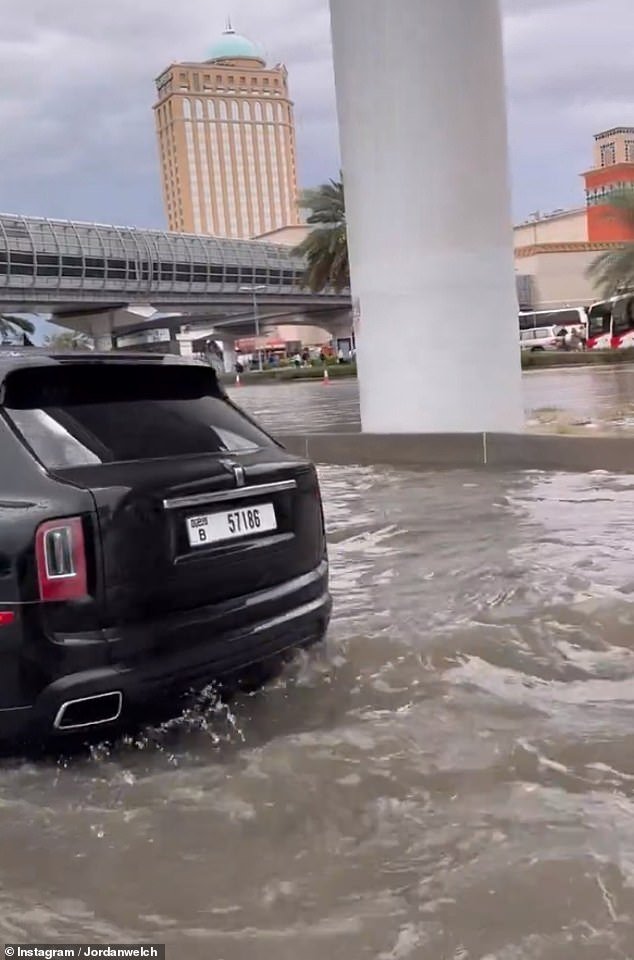 Waves begin to crash on the road as cars are brought to a halt in Dubai