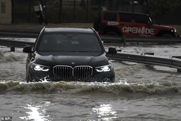 An SUV stops while trying to drive through standing water in Dubai, United Arab Emirates, Tuesday, April 16, 2024
