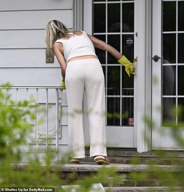 Nadine Menendez opens one of the side doors of her home while wearing her yellow gloves