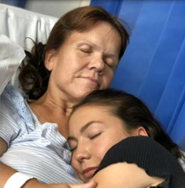 Samantha Davis faced death in 2019 when she fell ill with sepsis ahead of a family vacation.  Above: Being hugged by her daughter in the hospital