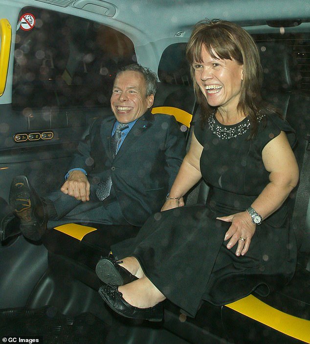 Warwick and Samantha smile and hold hands in the back of a taxi as they attend the Pride of Britain Awards at the Grosvenor House Hotel in London in October 2014