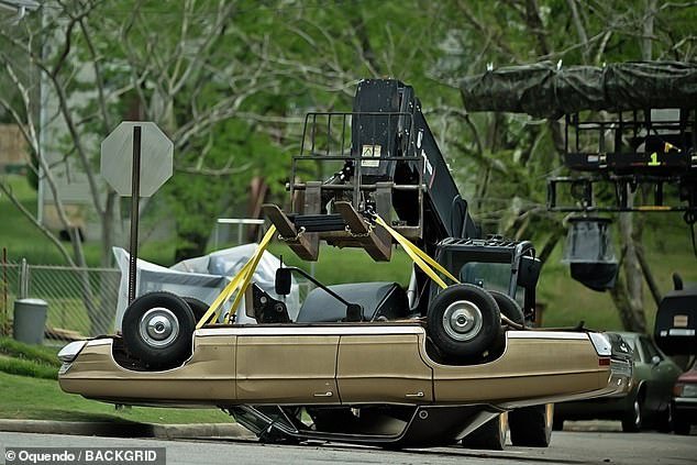 The scene filmed that day apparently involved an overturned car, as a crane could be seen lowering a vintage car upside down onto the street.