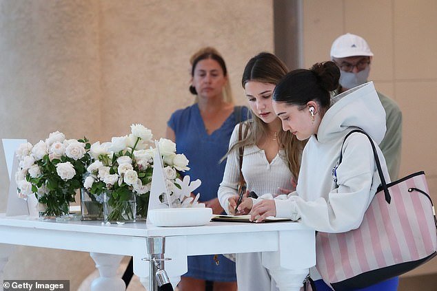 Shoppers sign a book of condolence during the reopening of Westfield Bondi Junction shopping center on April 19