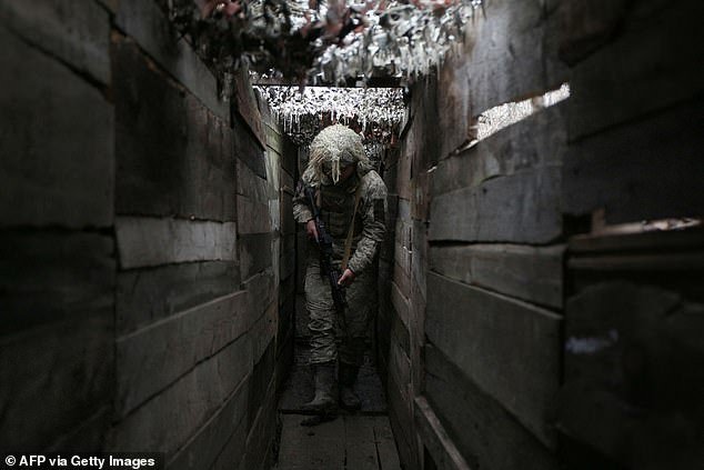 Ukrainian soldier walks along a trench on the front line with Russian-backed separatists, not far from the city of Avdiivka, Donetsk region, on December 10, 2021
