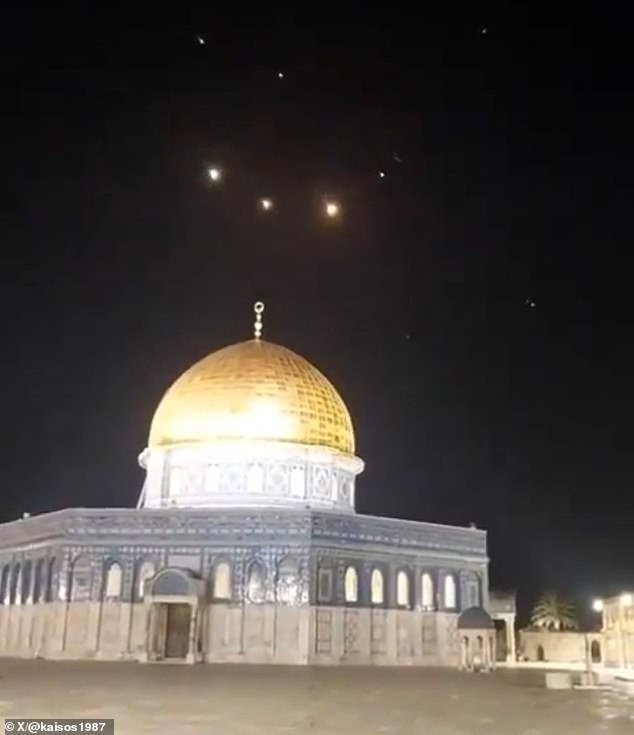 Missile trails are visible in the sky over Jerusalem's Al-Aqsa Mosque as Iranian missiles are intercepted by air defenses