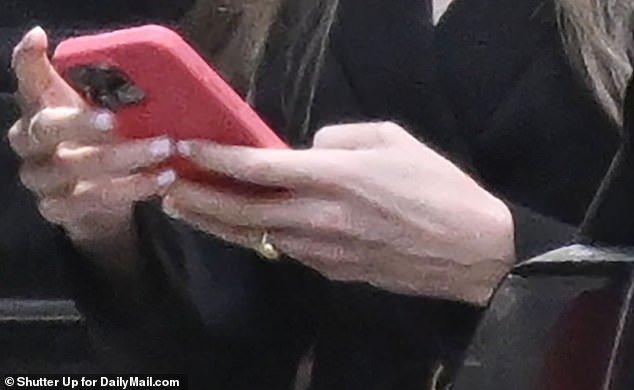 The 28-year-old deputy communications chief stepped out from between a pair of black SUVs while typing on her phone.  Above is a close-up of the ring