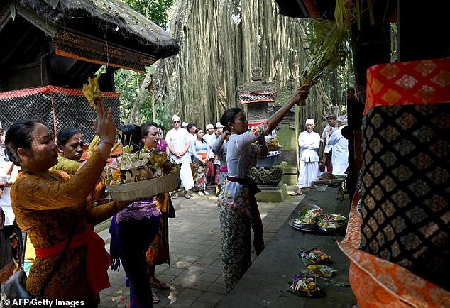 Balinese take part in a purification ritual at Beji Temple, located in a monkey sanctuary in Ubud on the Indonesian holiday island of Bali, on August 15, 2019