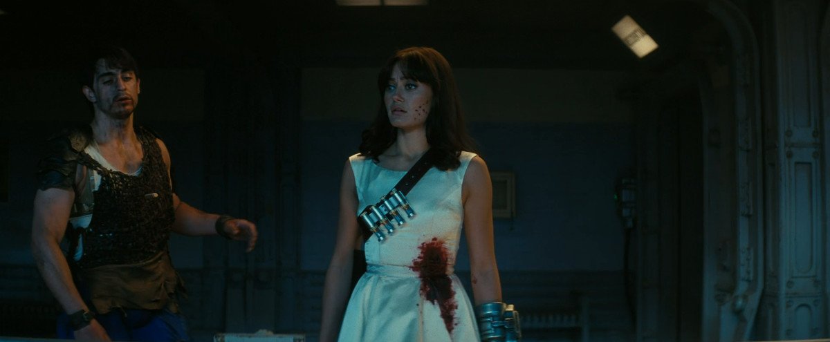 Lucy (Ella Purnell) in a bloody wedding dress, with tranquilizer darts over her shoulder, in Fallout