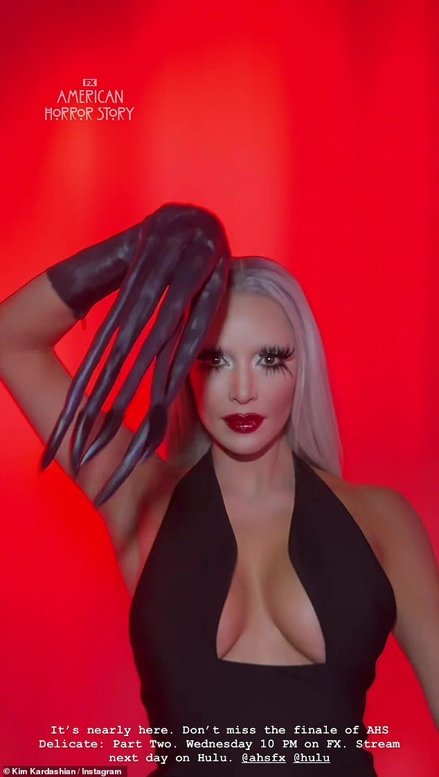 She posed in costume gloves and an icy platinum blonde wig, a bold red lip and spidery false eyelashes.