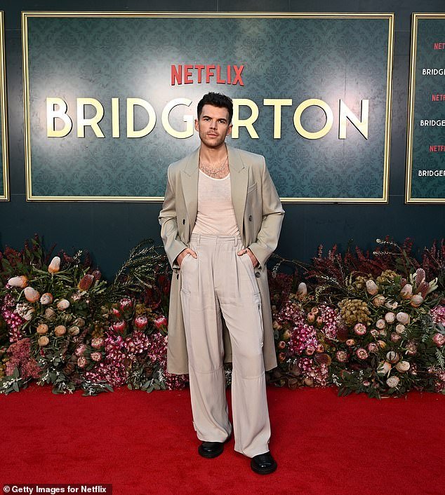He opted for a beige trench coat over a semi-sheer cream shirt and wide trousers to match his jacket