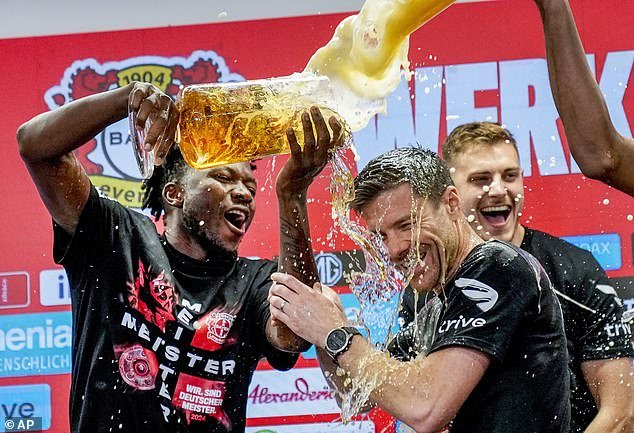 Alonso is doused in beer as Leverkusen celebrate their historic Bundesliga victory