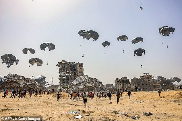 People rush to land humanitarian aid packages dropped over the northern Gaza Strip