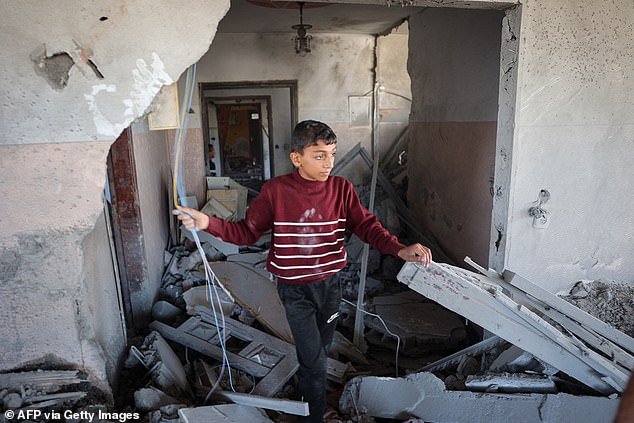 A Palestinian child checks the rubble of a house hit by an overnight Israeli bombardment in Rafah