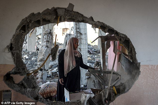 A Palestinian woman checks the rubble of a house hit by an Israeli bomb attack in Rafah in the southern Gaza Strip on April 20