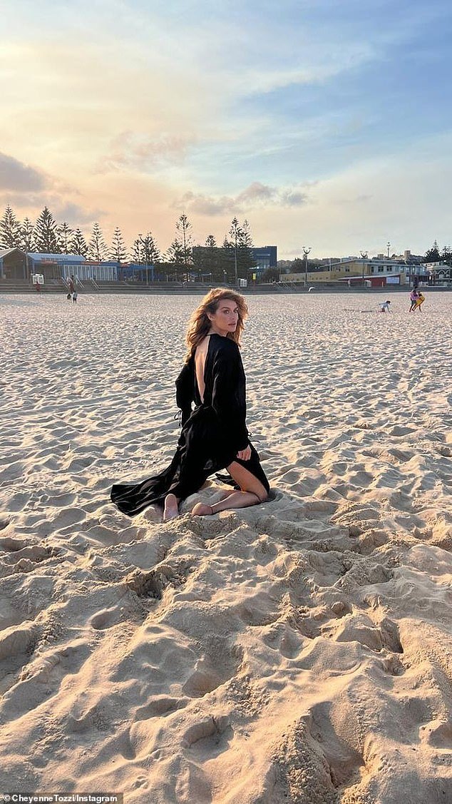 In one image, the Face Australia star was seen kneeling on the sand, wearing a sheer black kaftan
