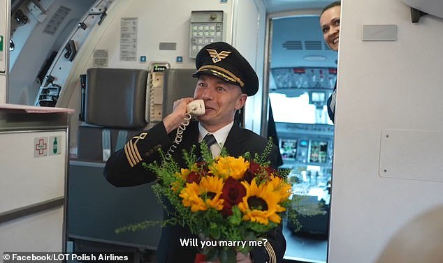 The pilot pulled out a large bouquet of flowers before getting down on one knee and asking if Paula would marry him