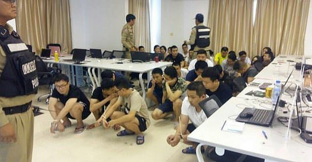 Experts have now warned that crime gangs are fueling an 'explosion' of human trafficking that is reaching the entire world and earning Chinese criminals $3 trillion a year.  In the photo, Chinese nationals have been arrested in connection with an online telecom scam in Cambodia