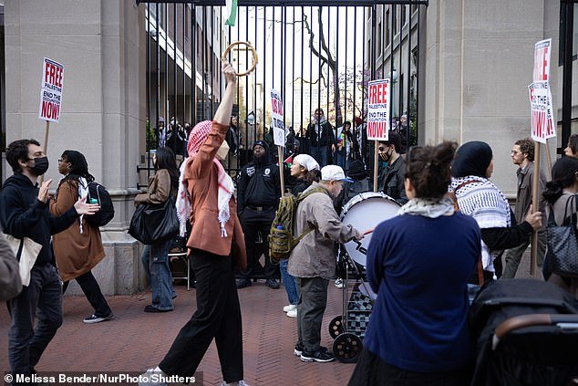 Palestinian demonstrators gather in protest both inside and outside the closed gates of Columbia University's campus
