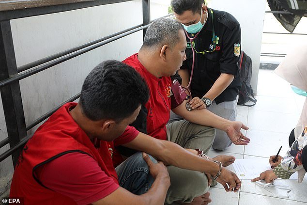 An Aceh man receives a medical check-up before being punished with a cane for violating Sharia law