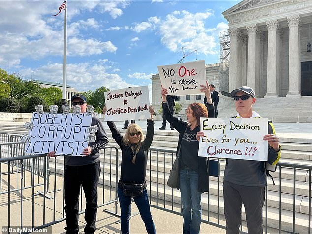 Diana Neary holds a sign with fellow protesters outside the Supreme Court on April 25 that reads 'No one is above the law'