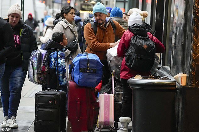 An immigrant family stands with their belongings outside the Roosevelt Hotel in New York