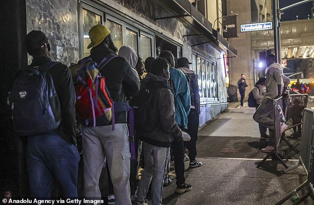 Asylum seekers line up outside the historic Roosevelt Hotel, converted into a city-run shelter for newly arrived migrant families in New York City