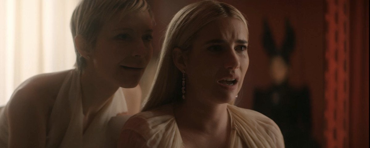 Emma Roberts and a blonde woman in a pixie cut sing together. 
