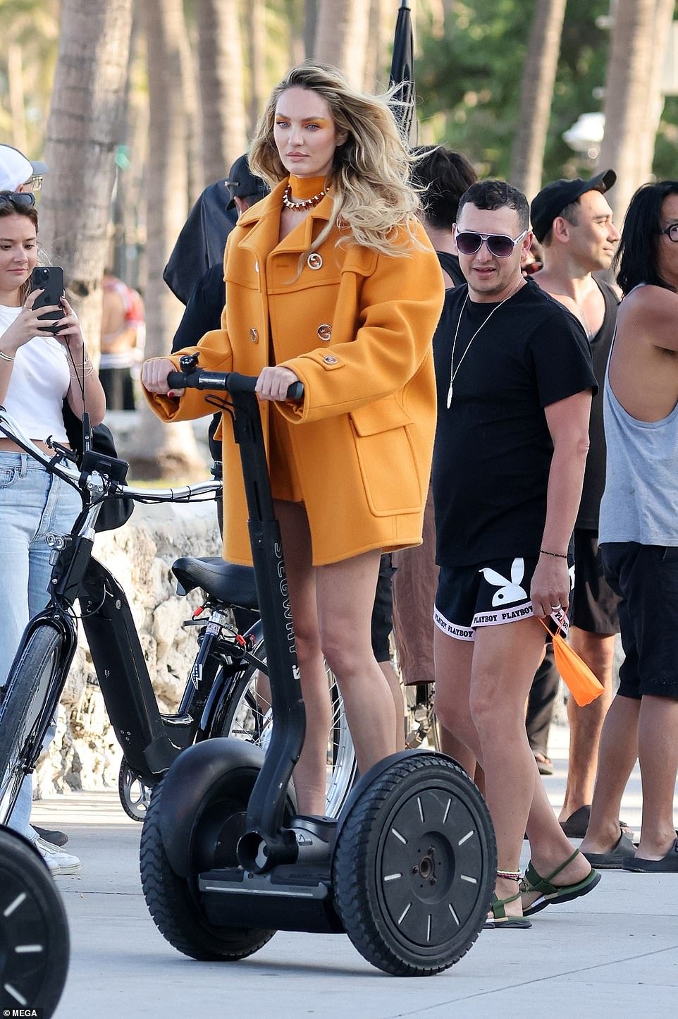 Candice showed off her legs in a thigh-grazing, burnt orange dress, paired with the matching coat - which also had large gold buttons